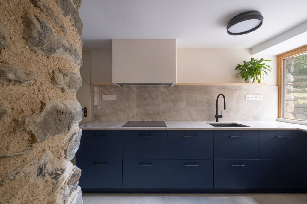 Cocina con frentes azules y encimera de piedra