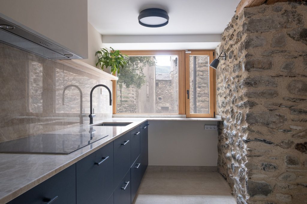 Cocina con ventana al casco antiguo y muro de mampostería
