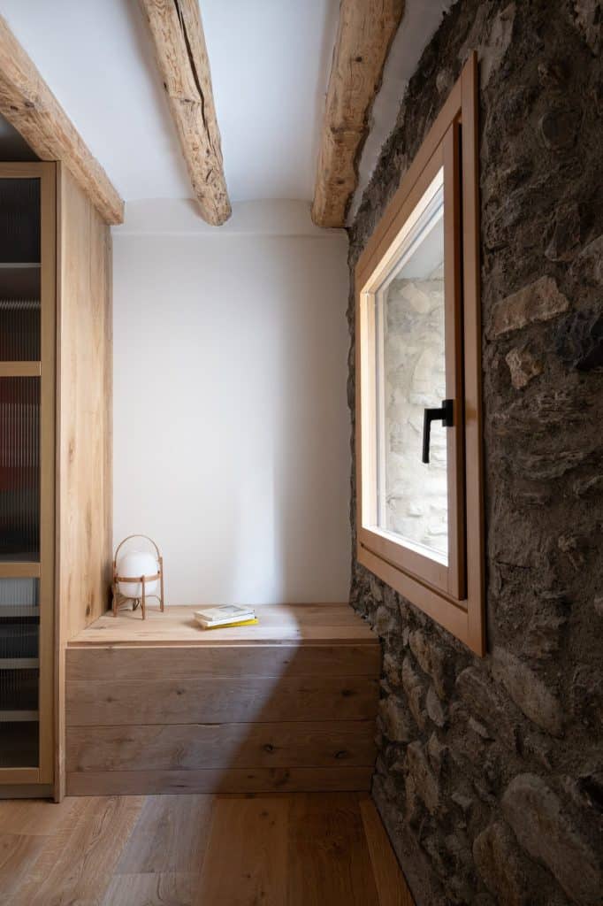 Banco de madera junto a la ventana del dormitorio