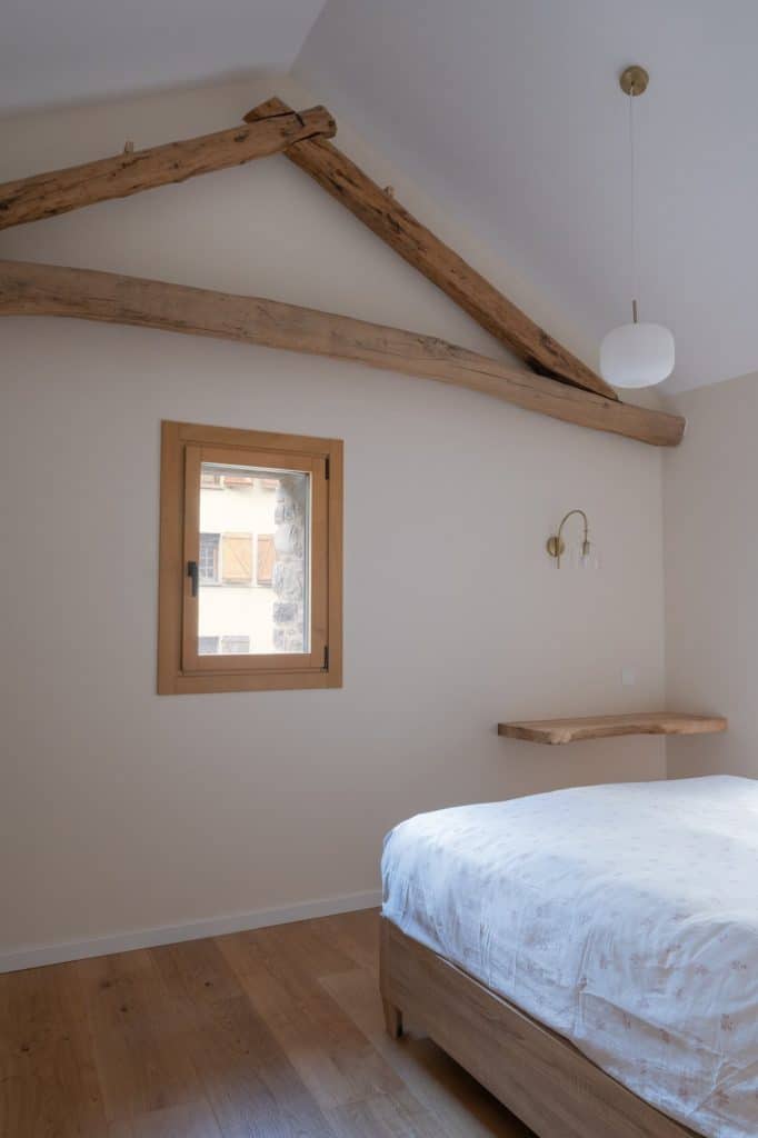 Dormitorio bajo cubierta con estructura de madera vista
