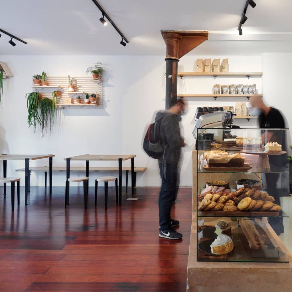 Clientes junto a la barra y la vitrina de la cafetería
