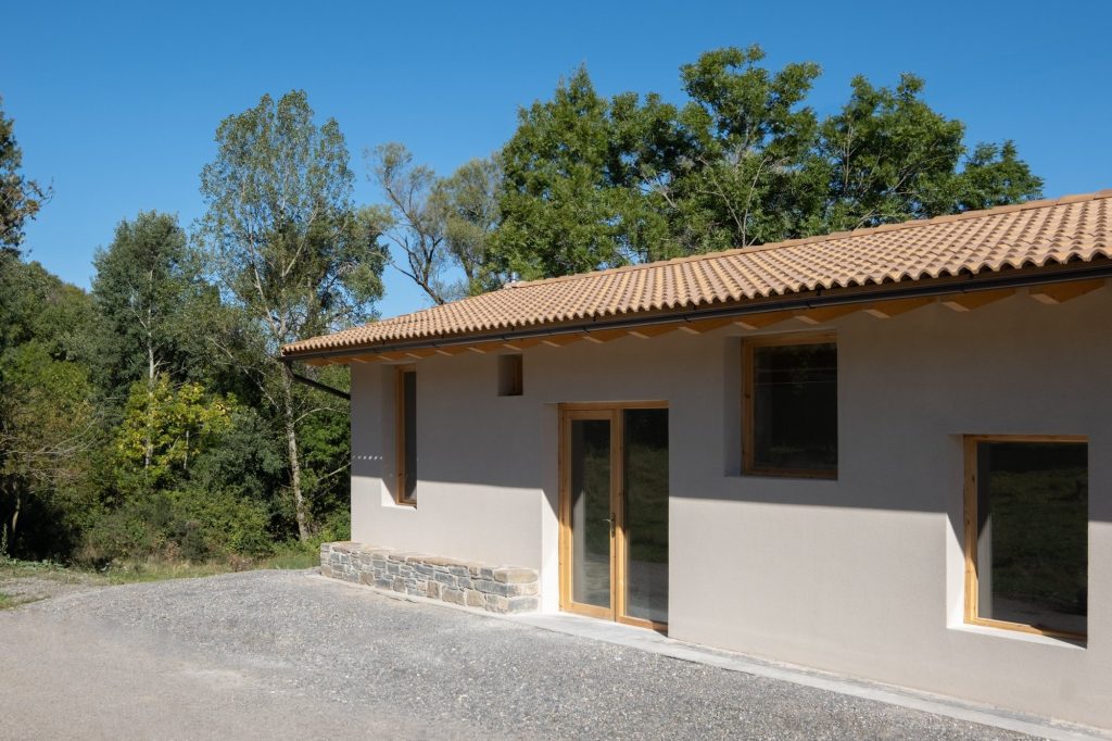 Fachada sur en escorzo con alero de madera y cubierta de teja