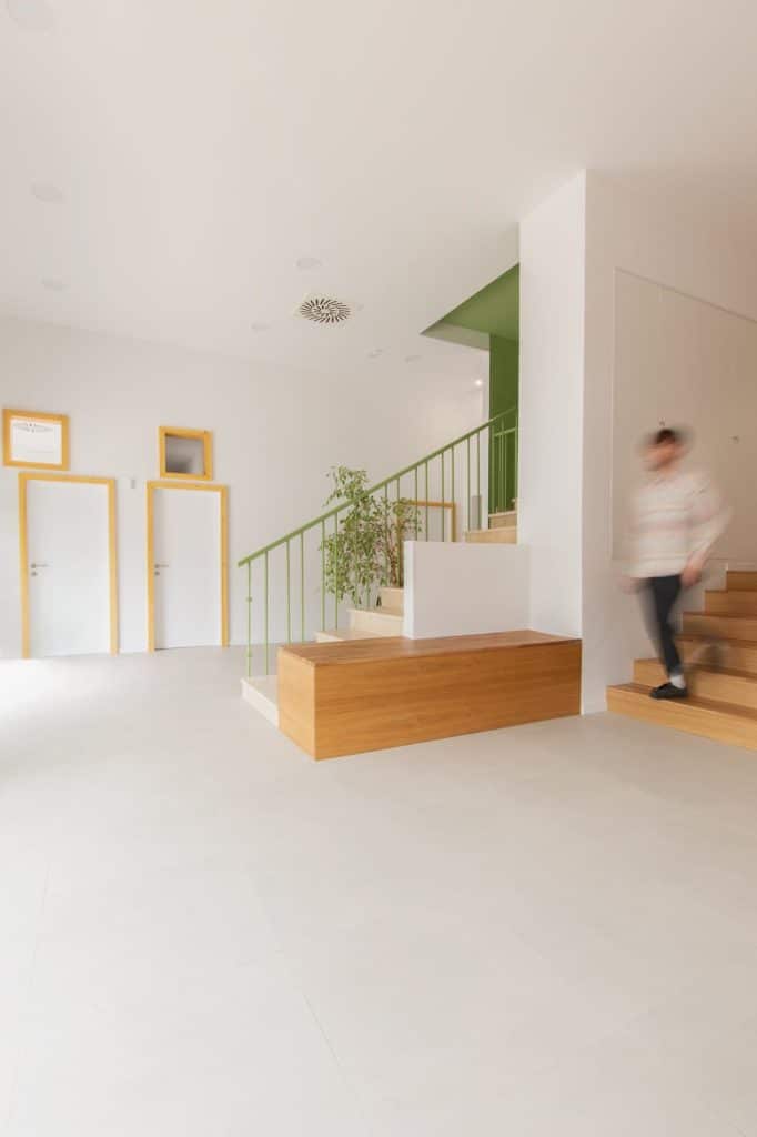Banco y escalera de madera junto a la escalera principal en verde