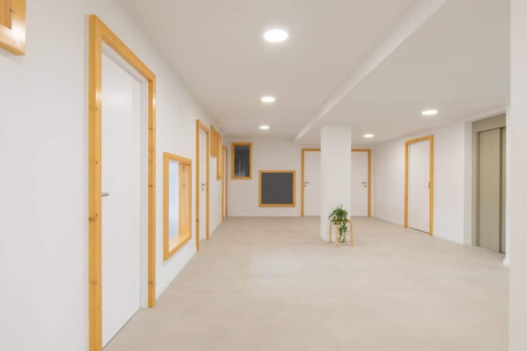 Distribuidor de la planta de oficinas con puertas y huecos enmarcados en madera