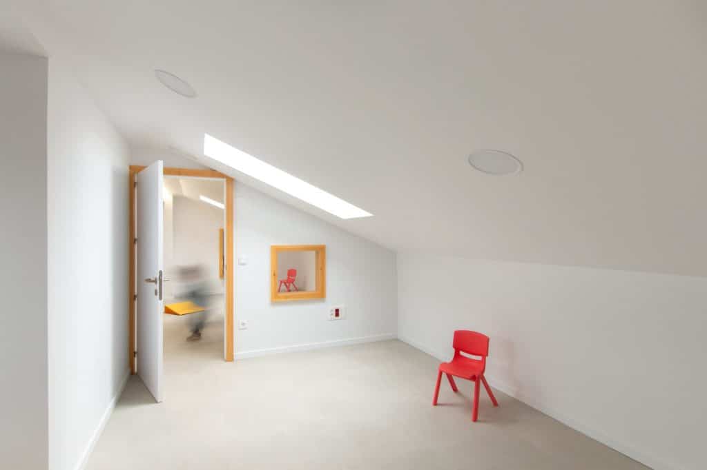 Sala bajo cubierta con lucernario y silla roja