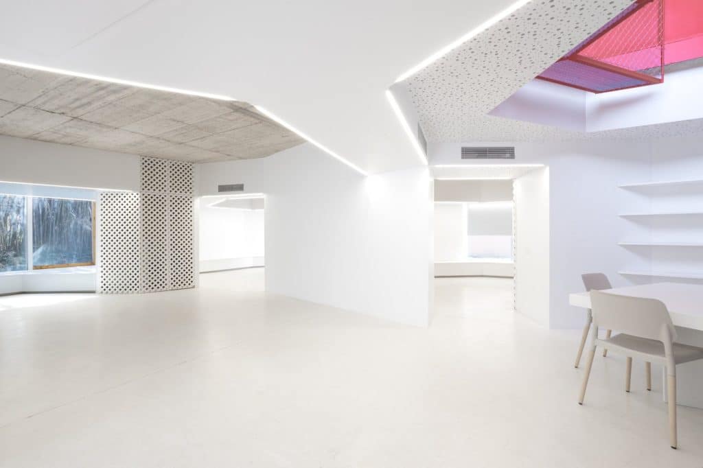 Espacio interior abierto con iluminación lineal y lucernario rojo