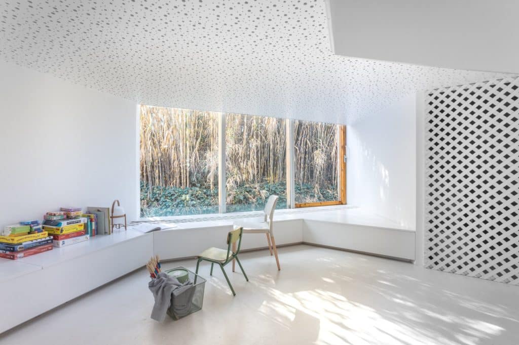 Sala de juegos con banco corrido junto a la ventana y cañaveral exterior