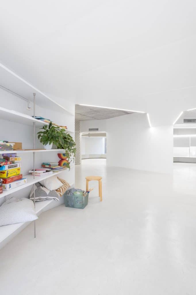 Estantería con juegos y cojines junto al espacio de paso