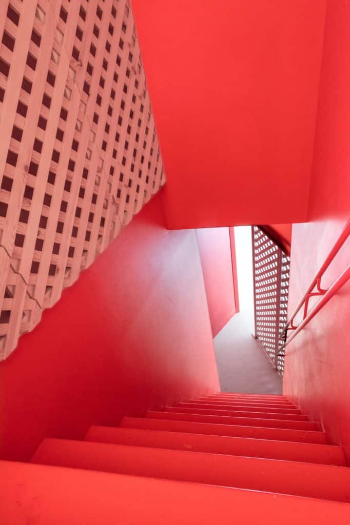 Escalera roja con celosía de madera