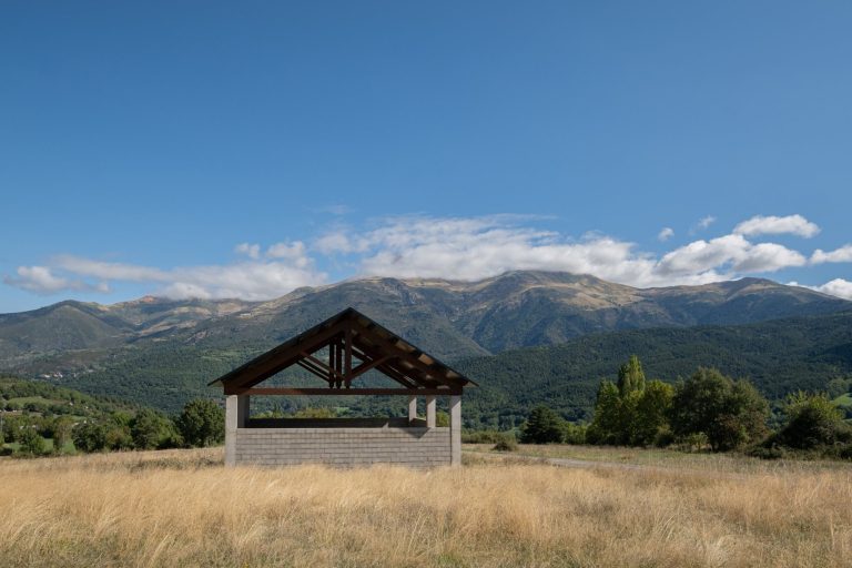 Nave abierta de almacén municipal en Bisaurri con las montañas al fondo