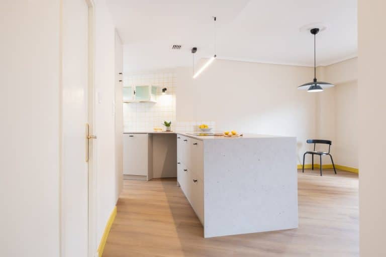 Cocina abierta al comedor con península de frente gris y lámpara negra