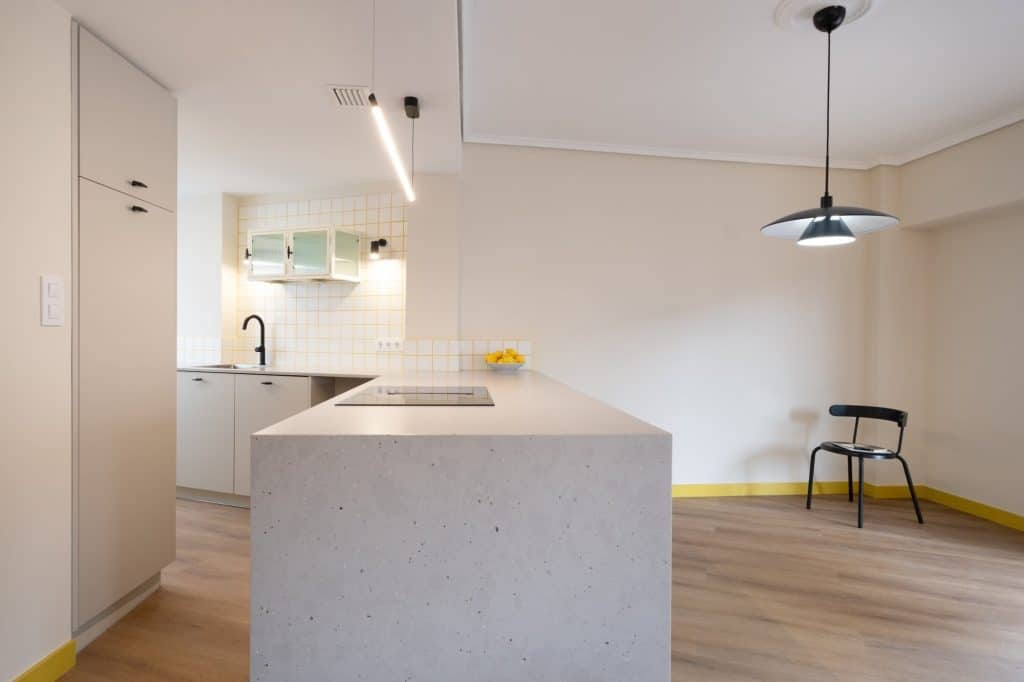 Cocina con península y alicatado blanco de juntas amarillas