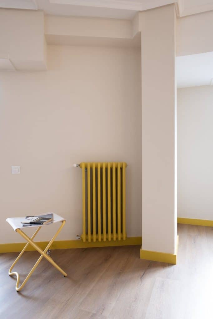 Radiador pintado de amarillo junto al pilar