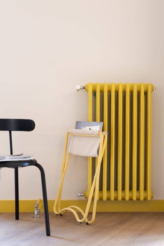 Radiador amarillo con revistero y silla negra