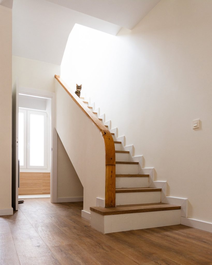 Escalera con pasamanos de madera y luz cenital