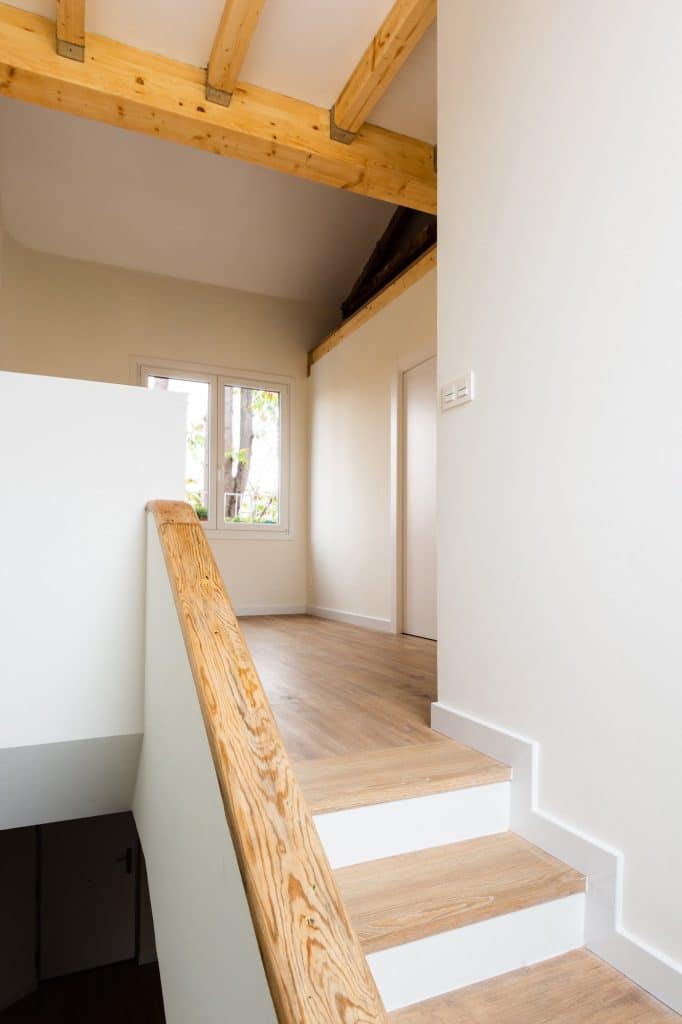 Llegada de la escalera a la planta alta con vigas de madera